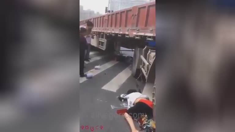 Lady on a scooter under the wheels of a truck