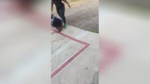 A girl hammers her rival in the road