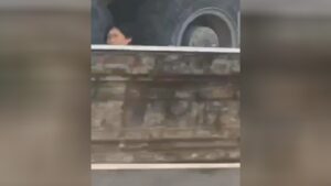 A crushed male keeps an eye out from under the wheel of a truck