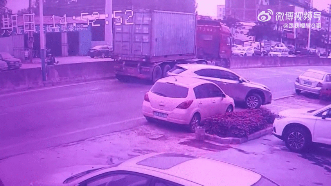 A Car Moving In Reverse Pushed A Motorcyclist Under A Truck