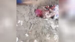 bound man in shallow grave gets pickaxe to the head